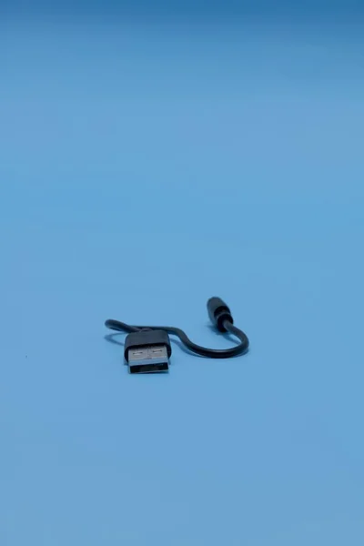Mavi Arkaplan Üzerinde Tipinden Micro Usb Kablosuna Dikey Bir Çekim — Stok fotoğraf