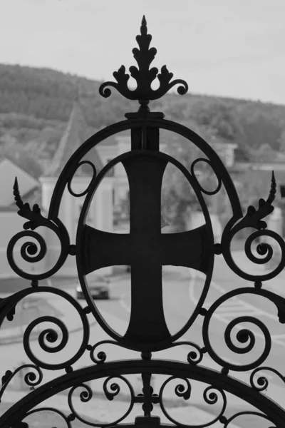 Eine Vertikale Graustufenaufnahme Eines Dekorativen Metallkreuzes Auf Dem Tor Vor — Stockfoto