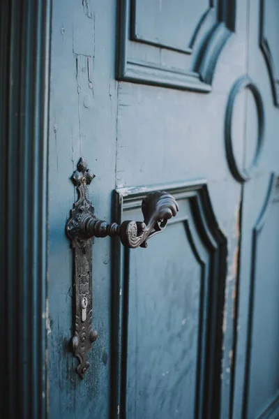 一把蓝色旧门上的老式金属把手的垂直特写镜头 — 图库照片