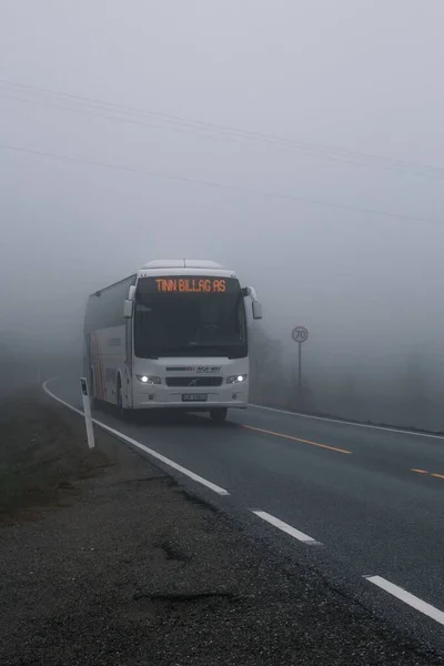 ノルウェーの山の霧の中を走るバスの垂直ショットが悪い条件で — ストック写真