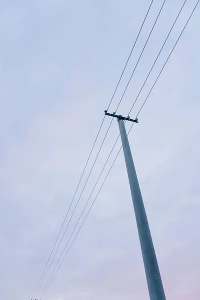 青い空にワイヤーを持つ背の高い電気塔の垂直低角度ショット — ストック写真