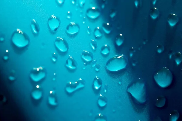 Egy Közeli Vízcsepp Egy Kék Fényes Felületen — Stock Fotó