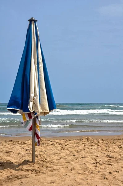Вертикальный Снимок Сине Белого Пляжного Зонтика Посаженного Песке Гандии Валенсия — стоковое фото