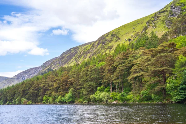 stock image A beautiful view of a green covered hills next to the lake