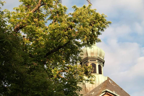 Mały Kościół Błękitnym Tle Zachmurzone Niebo Zielonym Drzewem Pierwszym Planie — Zdjęcie stockowe
