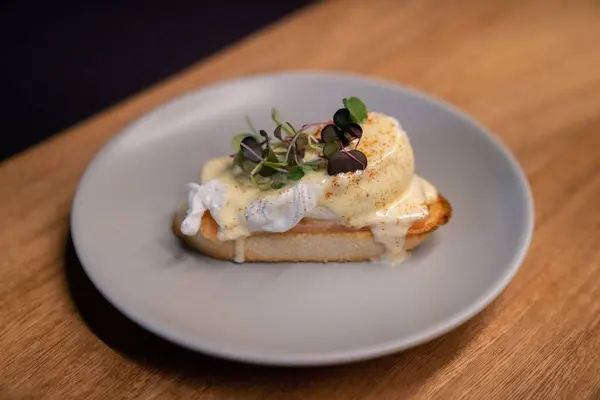 Ένα Κομμάτι Αυγά Μπένεντικτ Νόστιμη Γαρνιτούρα Ξύλινο Τραπέζι Στο Εστιατόριο — Φωτογραφία Αρχείου