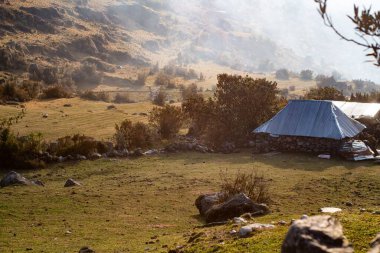 Peru And Dağları 'nda arka planda sisli kayalar olan küçük bir taş kulübe.