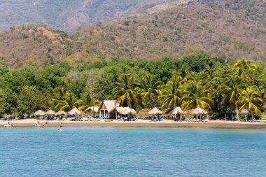 Güneşli bir günde kumsalda dinlenen insanlar.