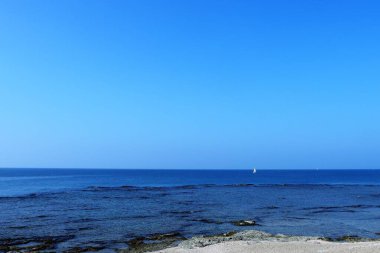 Ufukta seyreden bir teknenin deniz manzarası, Acre, İsrail