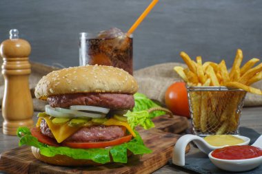 Köfte, sos, patates kızartması ve kola ile birlikte antika ahşap bir tahtanın üzerinde..