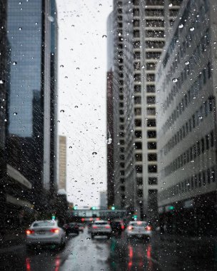 Calgary, Alberta 'daki ıslak bir gösterge panelinden görünen modern binaların ve arabaların dikey bir görüntüsü.