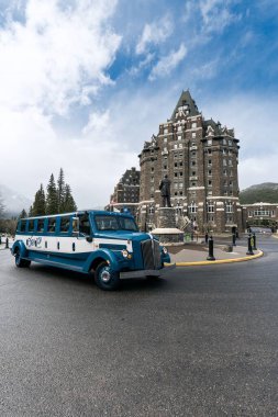 Kanada 'daki Banff Springs otelinin önüne park etmiş eski bir arabanın dikey görüntüsü.