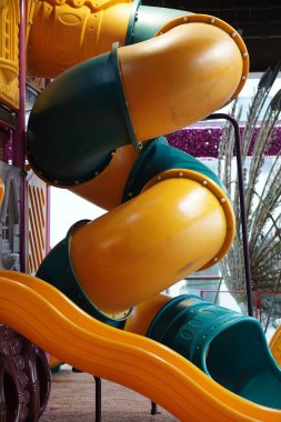 Yeşil sarı plastik bir kaydırak takımının dikey görüntüsü.