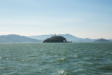 Alcatraz Adası 'nın büyüleyici bir görüntüsü ve eski hapishane, arka plandaki dağlar.