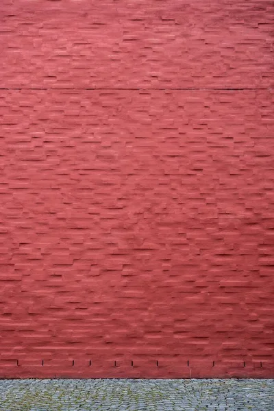 Pionowe Ujęcie Jasnoczerwonego Malowanego Ceglanego Muru Pobliżu Drogi — Zdjęcie stockowe