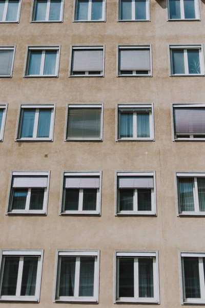 Yüksek Bir Binanın Beyaz Panjurlu Birçok Penceresinin Dikey Görüntüsü — Stok fotoğraf