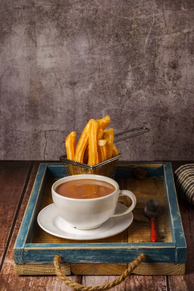 热巧克力在一个白色的杯子里 在一个木制桌子上的蓝色木制盘子里放着香菜 — 图库照片