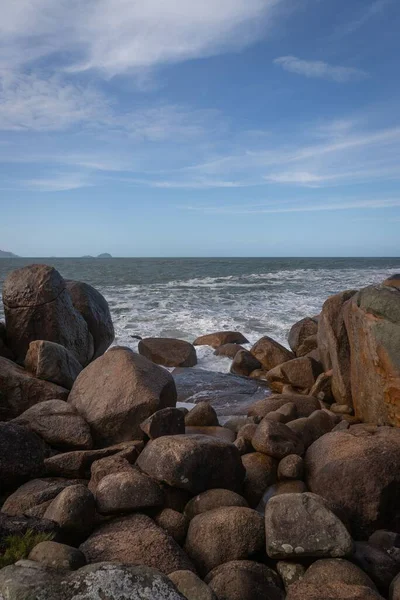 Вертикальный Вид Море Камнями Рядом Ясный Солнечный Фон Неба — стоковое фото
