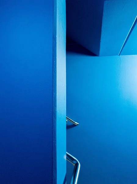 Wewnętrzne Ujęcie Krzywej Schodów Metalowymi Balustradami Niebieskimi Ścianami — Zdjęcie stockowe