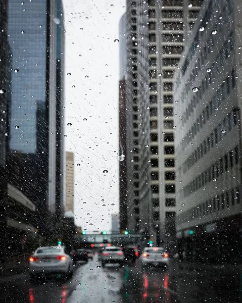 阿尔伯塔省卡尔加里市的一座通过湿湿的仪表板看得见的现代建筑和汽车的垂直截图 — 图库照片