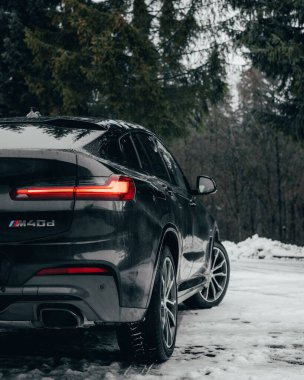 Kışın yol kenarında park edilmiş bir BMW X4M 'nin dikey çekimi.