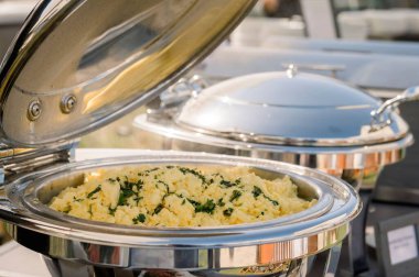 Bir etkinlikte çırpılmış yumurtalı gümüş bir tencere yakın çekim.