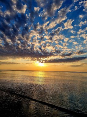 Gün batımında bir denizin dikey görüntüsü.