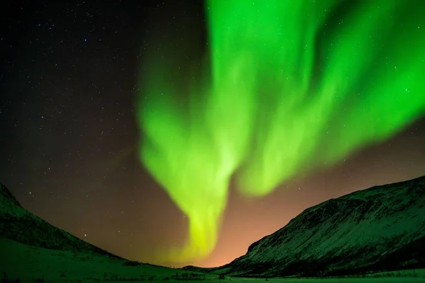 ノルウェーの山の上の明るい緑のオーロラの美しいショット — ストック写真