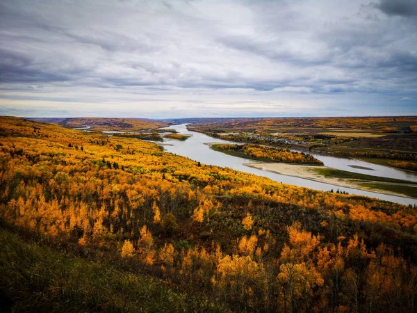 曇り空のカラフルな秋の日に川と木々の上に黄色とオレンジの葉の多く — ストック写真