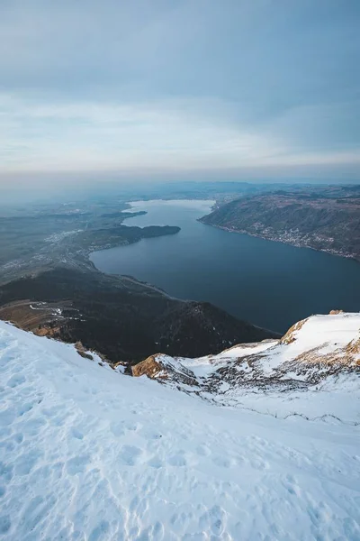 曇り空の下で山に囲まれた湖の垂直空撮 — ストック写真