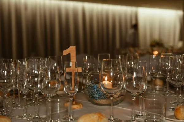 Egy Közelkép Borospoharakról Egy Vacsoraasztalon Egy Partin Számtáblával — Stock Fotó