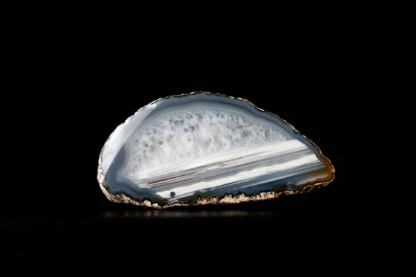 A closeup shot of a blue agate stone isolated against the black background