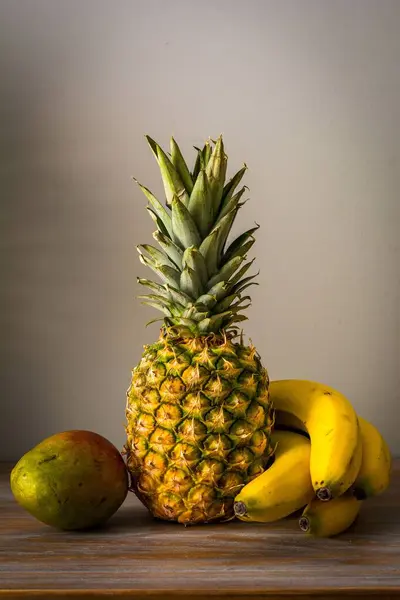 Uma Mesa Frutas Com Abacaxi Manga Bananas Juntos Uma Superfície — Fotografia de Stock