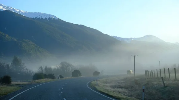 Uma Vista Panorâmica Uma Estrada Vazia Cercada Por Montanhas Nevoeiro — Fotografia de Stock