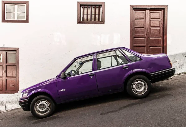Purple Car Tilted Street White Wall Brown Doors Background — Stock Photo, Image