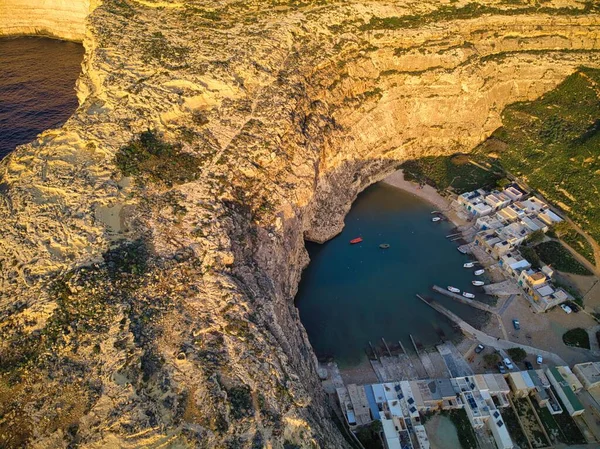 Dwejra 'nın hava günbatımı manzarası, Gozo adasındaki bir deniz suyu gölü. Küçük balıkçı köyü ve Deniz Tüneli. Malta 'daki İç Deniz Örneği.