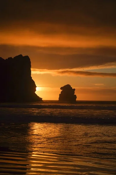 Vertical Shot Silhouettes Cliffs Beach Sunset — Stock Photo, Image