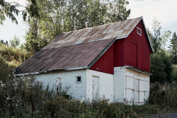 Una Cabaña Roja Blanca Con Techo Oxidado Erosionado Rodeado Vegetación —  Fotos de Stock