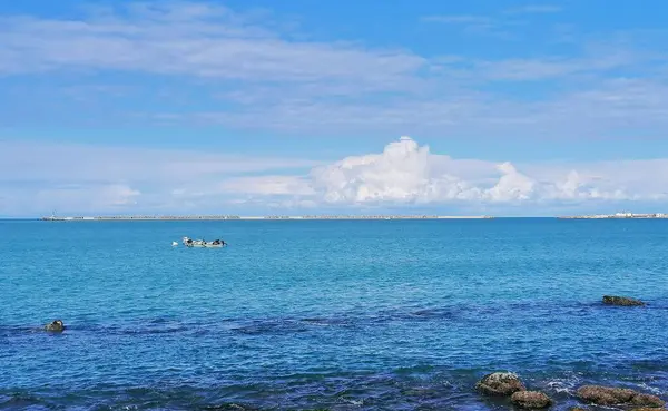 在乌云密布的蓝天下 有几艘船漂浮在海面上 拍出一副美丽的景象 — 图库照片