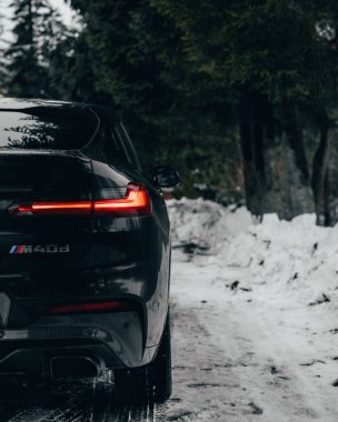 Kışın yol kenarında park edilmiş bir BMW X4M 'nin dikey çekimi.