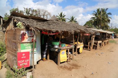 Kenya 'nın Ukunda kentindeki toprak yolda bir dizi Afrikalı fakir dükkan var.