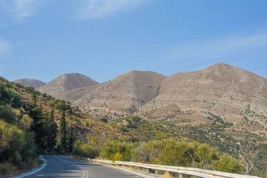 Güneşli bir günde mavi gökyüzü olan boş bir dağ yolu.