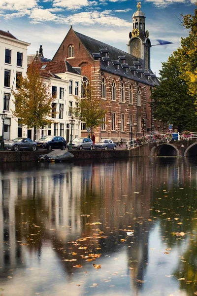 オランダ ライデンの秋の水の反射を伴う旧歴史大学の垂直ショット — ストック写真