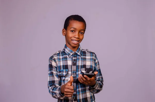 Мальчик Клетчатой Рубашке Держит Мобильный Телефон Фиолетовом Фоне — стоковое фото