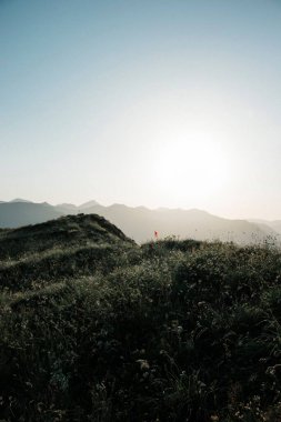 Gün batımında gökyüzüne karşı bir dağın dikey görüntüsü.