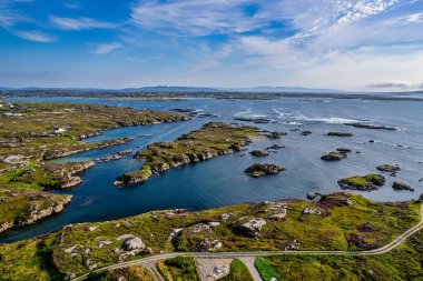 Mavi bir ufuk çizgisinden önce Donegal kıyısı boyunca uzanan bir yolun havadan görüntüsü.