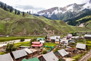 Jammu ve Kashmir, Hindistan 'daki Sonamarg Hill Trek' te küçük evleri olan güzel bir dağ manzarası.