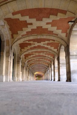 Paris, Fransa 'daki tarihi Place des Vosges kemerlerinin dikey çekimi
