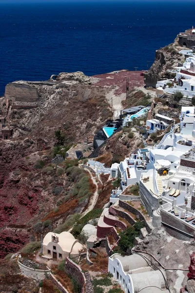 希腊阳光普照的海滨悬崖上的欧亚村建筑的垂直空中景观 — 图库照片