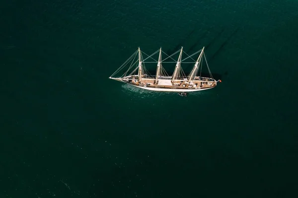緑の海水に帆のない白い船の空中写真 — ストック写真